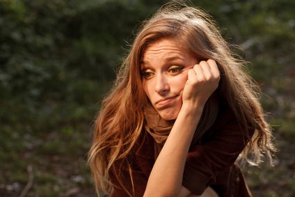 young woman sitting thinking about her problems looking away